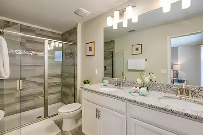 a bathroom with two sinks and a shower and a toilet at Casa 6Q c/ Piscina + Temas Disney – Storey Lake in Kissimmee