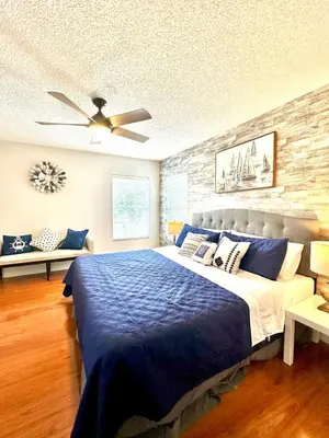 a bedroom with a blue bed with a ceiling fan at Disney Pixie Dust Villa in Kissimmee