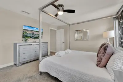 a bedroom with a white bed and a dresser at TVPM-4981WA/SL in Kissimmee