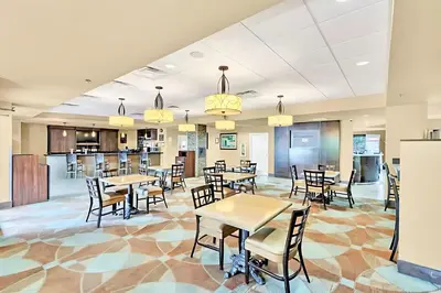a dining room with tables and chairs and a bar at Family-Friendly 1BR Apartment close to Disney World in Orlando