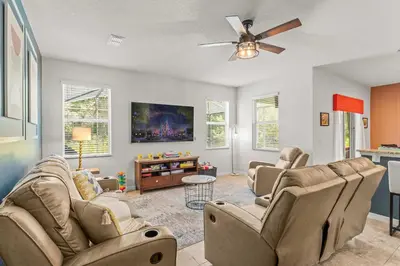 a living room with couches and a flat screen tv at Paradise Falls Stay for 13 in Kissimmee