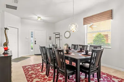 a dining room with a black table and chairs at Paradise Falls Stay for 13 in Kissimmee