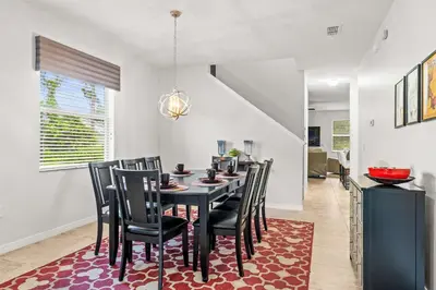 a dining room with a black table and chairs at Paradise Falls Stay for 13 in Kissimmee