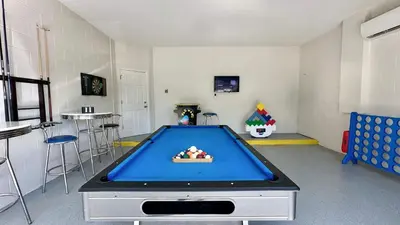a room with a pool table in the middle of it at Paradise Falls Stay for 13 in Kissimmee