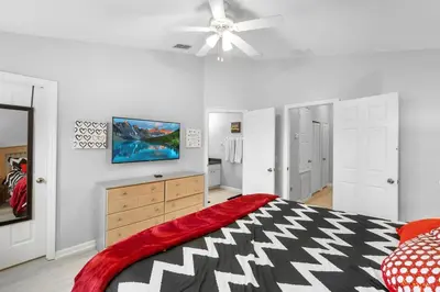 a bedroom with a bed and a tv on the wall at Disney Dream in Orlando