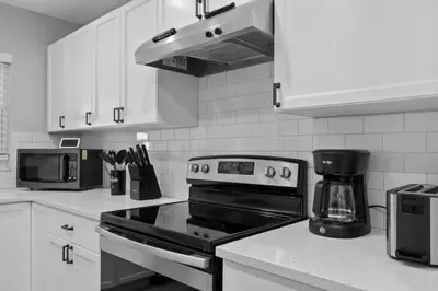 a kitchen with a stove and a microwave at Red Jordan Boho Style Vacation Home in Orlando