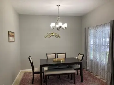 a dining room with a black table and chairs at Orlando HomeDisney and beach in Orlando