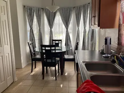 a kitchen with a table and chairs and a window at Orlando HomeDisney and beach in Orlando