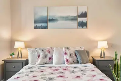 a bedroom with a bed with three paintings on the wall at Secret Resort Kissimmee Lakeview Condo in Kissimmee