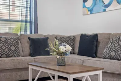 a living room with a couch and a table with flowers at Magical Disney Getaway- Belle Potter & Minions in Kissimmee