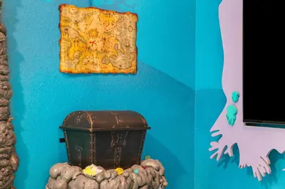 a blue wall with a painting and a chest on it at Windsor Hills Family-Friendly 3BR Pool Townhome in Orlando