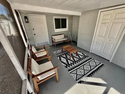 a porch with chairs and a table and a door at Relaxing 3BR Home Near Orlando Downtown & Parks in Orlando