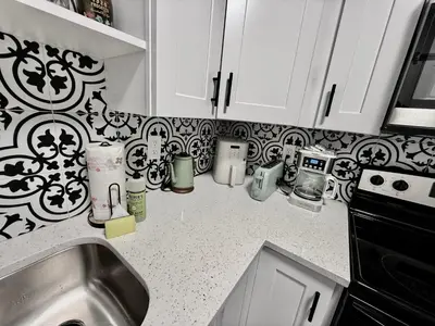a kitchen counter with a sink and black and white tiles at Relaxing 3BR Home Near Orlando Downtown & Parks in Orlando