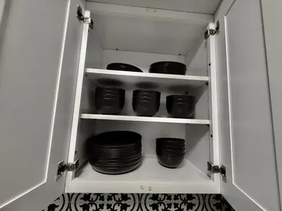 a cupboard filled with plates and bowls at Relaxing 3BR Home Near Orlando Downtown & Parks in Orlando