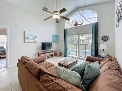 a living room with a couch and a ceiling fan at Family Fun Tropical Home in Kissimmee