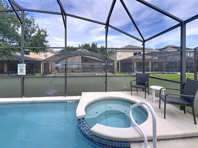 a swimming pool with a hot tub and chairs at Family Fun Tropical Home in Kissimmee