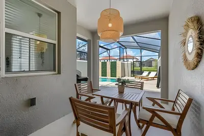 a dining room with a table and chairs and a patio at Casa 4Q Storey Lake c/ Piscina e Quartos Disney in Kissimmee