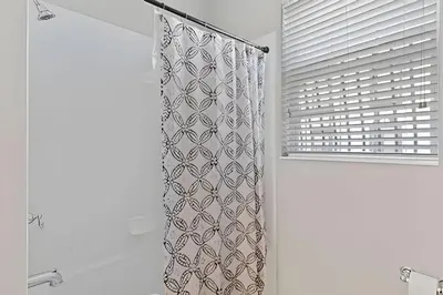 a shower curtain in a bathroom with a window at Apartamento 3Q Vista Cay Perto dos Parques in Orlando