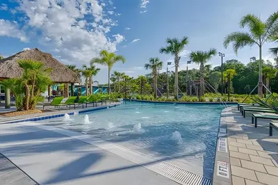 a swimming pool at a resort with palm trees at Casa 4Q Disney c/ Piscina e Quartos Temáticos in Kissimmee