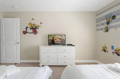 a bedroom with a bed and a tv on a dresser at Charmosa Casa 4Q c/ Piscina - Perto da Disney in Kissimmee