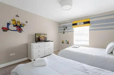 a bedroom with two beds and a tv in it at Charmosa Casa 4Q c/ Piscina - Perto da Disney in Kissimmee