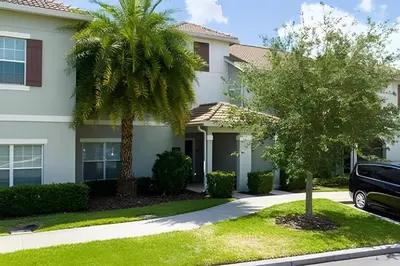 a house with a palm tree in front of it at Casa 4Q c/ Piscina e Temas Mickey & Harry Potter in Kissimmee