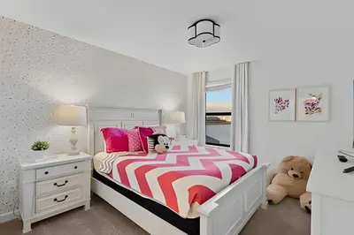 a white bedroom with a bed and a white nightstand at Villa 6Q Luxo c/ Piscina, Spa e Perto da Disney in Kissimmee