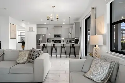 a living room with a couch and a kitchen at Villa 6Q Storey Lake c/ Piscina, Spa e EV Charger in Kissimmee