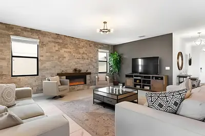 a living room with white furniture and a brick wall at Villa 6Q Storey Lake c/ Piscina, Spa e EV Charger in Kissimmee