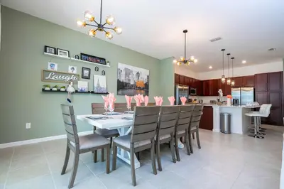 a dining room and kitchen with a table and chairs at Family Friendly 12Bd w Jacuzzi Veranda Palms 4401 in Kissimmee
