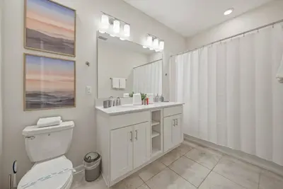 a bathroom with a toilet and a sink and a mirror at Cozy 2 Bedrooms At Storey Lake in Kissimmee