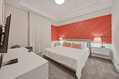 a bedroom with a white bed and a red wall at Cozy 2 Bedrooms At Storey Lake in Kissimmee