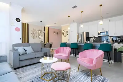 a living room with a couch and pink chairs at Casa 4Q c/ Piscina e Quartos Temáticos in Kissimmee