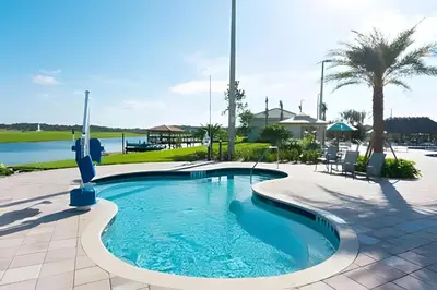 a pool at a resort with a palm tree at Casa 4Q c/ Piscina e Quartos Temáticos in Kissimmee