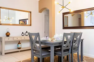 a dining room with a table and chairs and a mirror at Casa 4Q Disney c/ Piscina e Quartos Temáticos in Kissimmee