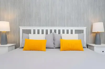 a bedroom with a white bed with two yellow pillows at Casa 4Q Disney c/ Piscina e Quartos Temáticos in Kissimmee