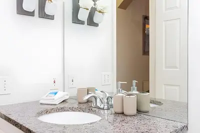 a bathroom with a sink and a mirror at Casa 4Q Disney c/ Piscina e Quartos Temáticos in Kissimmee