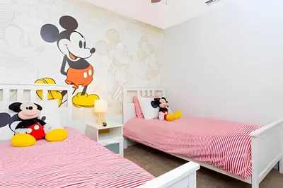 a bedroom with two beds and a mickey mouse mural at Casa 4Q Disney c/ Piscina e Quartos Temáticos in Kissimmee