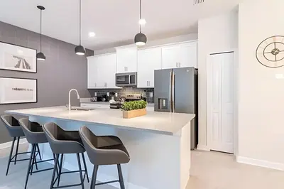 a kitchen with a large island with bar stools at Casa 4Q Storey Lake c/ Piscina e Mickey in Kissimmee
