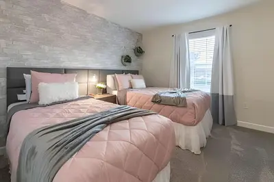 a bedroom with two beds and a brick wall at Casa 4Q Storey Lake c/ Piscina e Mickey in Kissimmee