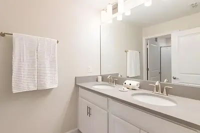 a bathroom with two sinks and a large mirror at Casa 4Q Storey Lake c/ Piscina e Mickey in Kissimmee