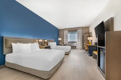 a hotel room with two beds and a television at Comfort Inn & Suites Orlando Sanford Airport in Sanford