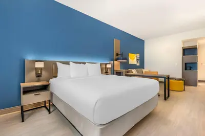 a large white bed in a room with a blue wall at Comfort Inn & Suites Orlando Sanford Airport in Sanford