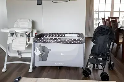 a baby cart in a room with a table and a stroller at Casa 4Q c/ Piscina e Game Room – Perto Disney in Orlando