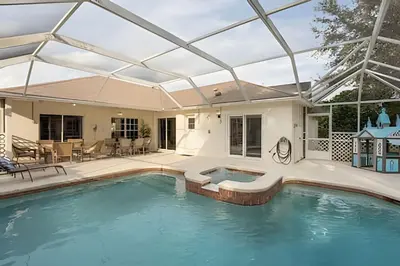 an indoor swimming pool with a glass roof at Casa 4Q c/ Piscina e Game Room – Perto Disney in Orlando