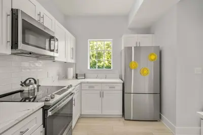 a white kitchen with a refrigerator and a window at Sleek & Stylish Stay Mins to Magic MP68 in Orlando