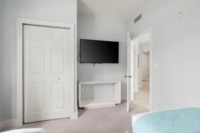 a white room with a flat screen tv on a wall at Serene Disney Getaway Designer Style MP61 in Orlando