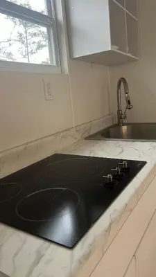 a black counter top in a kitchen with a sink at Casita próximo Disney - mickeyfl-2 in Kissimmee