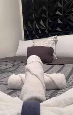 a bed with white blankets and pillows on it at Casita próximo Disney - mickeyfl-2 in Kissimmee