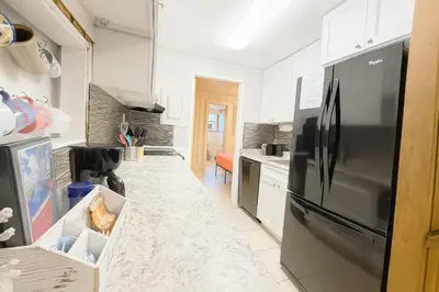 a kitchen with a black refrigerator and white cabinets at Cottage-pvt Lake & Pool Access Near Disney Wporch in Clermont